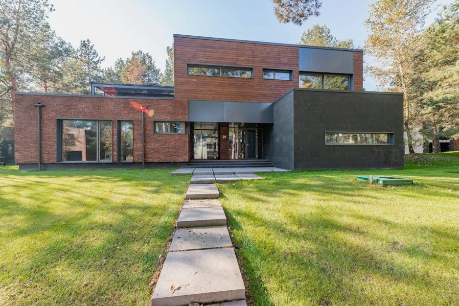 Edificio per uffici moderno con facciata in vetro e piante, simbolo di architettura sostenibile.